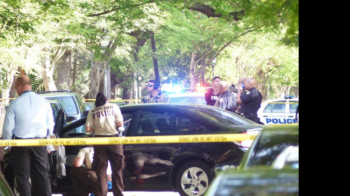 
Police officers investigate the scene of a shooting Saturday, July 4, 2015, in Coral Gables, Fla. 
