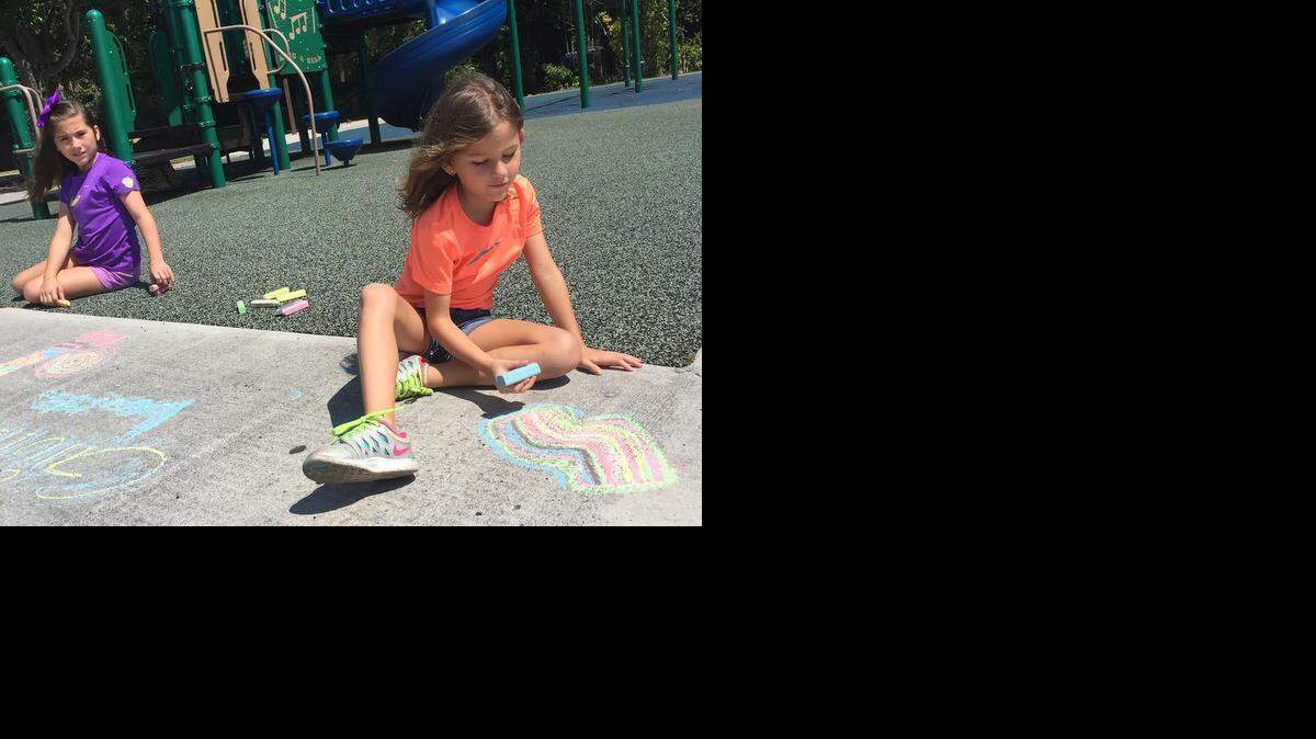 
Julia Lavito, 7, draws on the playground at Alice Wainwright Park in Coconut Grove Sunday afternoon with her 10-year-old sister, Silvana, left. They are both on spring recess from St. Stephen's Episcopal Day School in Coconut Grove. 
