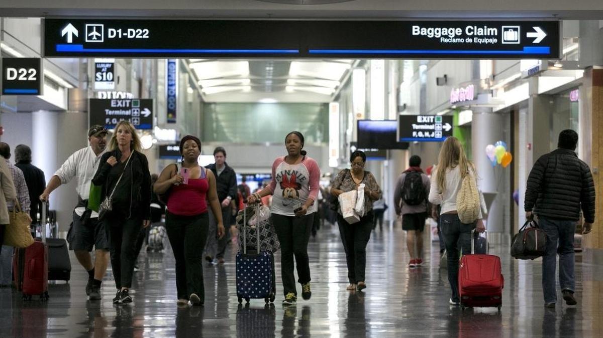 Passengers walk through a concourse at Miami International Airport in December 2015.