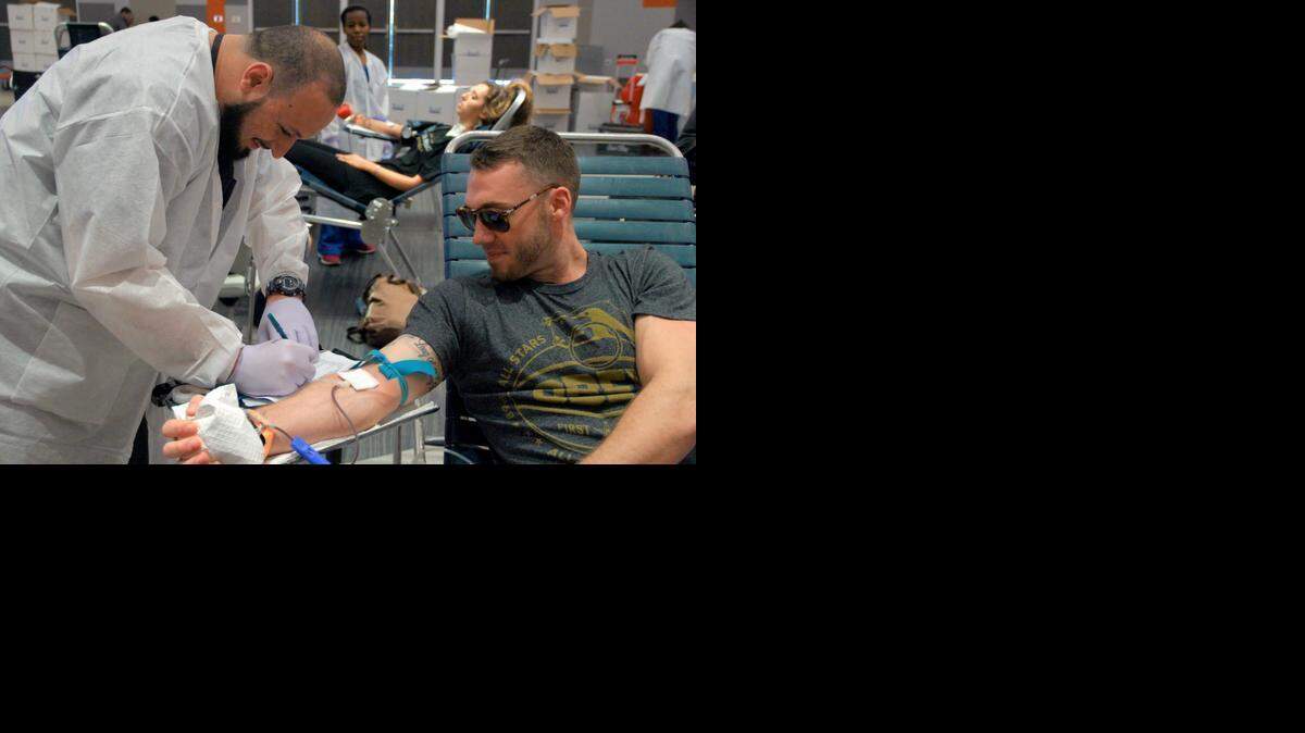 
OneBlood medical worker Cristian Barbinella, left, draws blood from Sigma Chi fraternity member Connor Berger, right, at a blood drive during Greek Week at the University of Miami.
