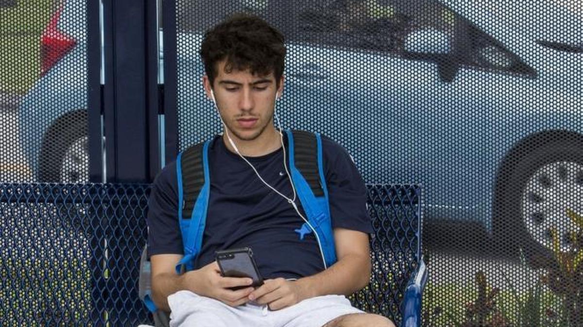 FIU freshman Christian Claro awaits a shuttle to take him off campus at Florida International University’s main campus in southwest Miami-Dade on Monday, March 19, 2018.
