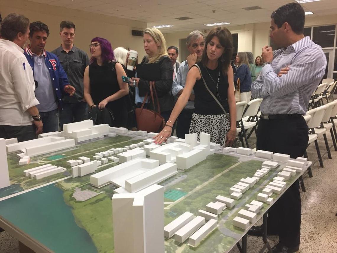 Residents and city officials look over two models of the proposed Legions West project following Wednesday’s town hall meeting. The model on the left is what’s proposed, and the one on the right what the developer says it could build without a Special Area Plan.