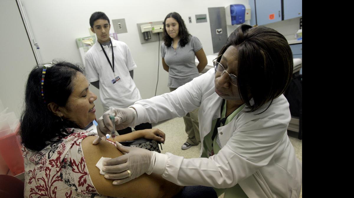 
Nurse Harriette Wilkins prepares to inject the H1N1 vaccine into 49-year-old Daisy Caban-Martinez at the Cutler Bay Doris Ison Health Center in 2009, a Community Health of South Florida facility. 
