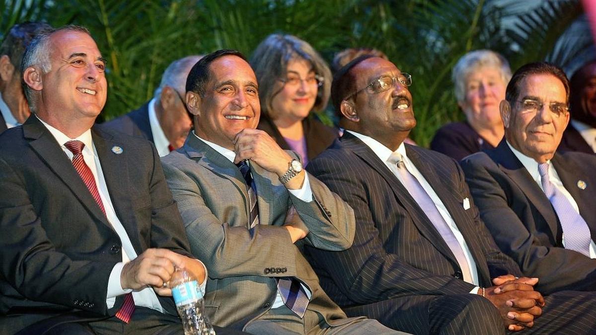 Miami-Dade County commisioners Esteban Bovo Jr., Joe Martinez, Dennis Moss and Xavier Suarez react as Mayor Carlos Gimenez (not pictured) speaks to the audience on the day newly elected or re-elected officials were sworn in.
