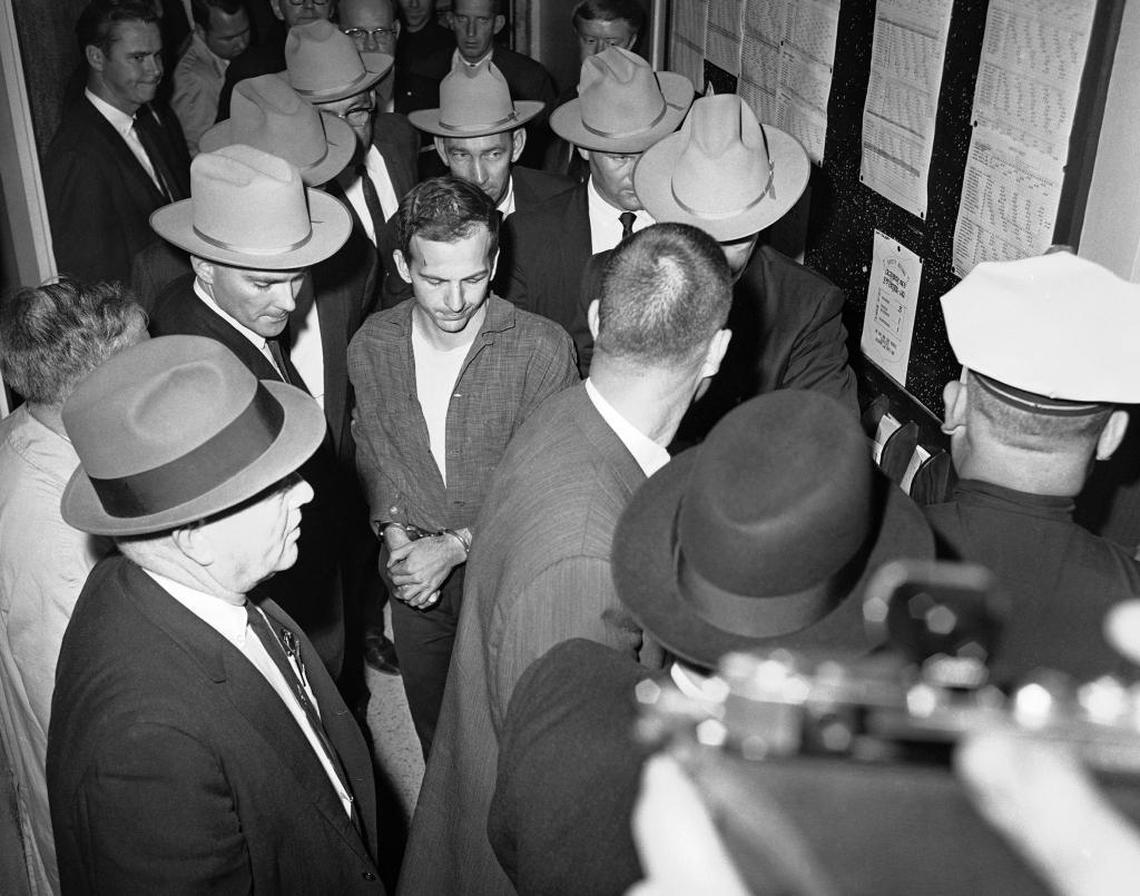 Lee Harvey Oswald, center, is shown in custody at a Dallas police station, Nov. 23, 1963.