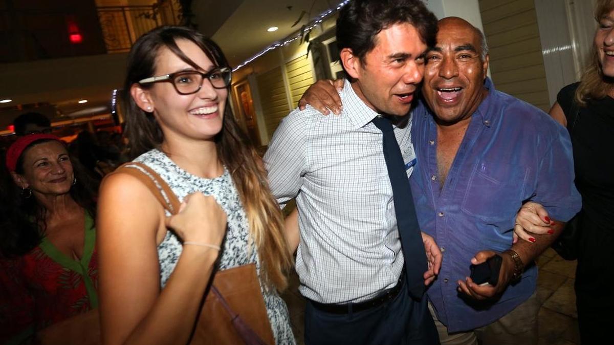 Miami City Commission Candidate Ken Russell (center) is greeted by Campaign Coordinator Daniela Martins (left) and campaign worker Marcos Pineda at The Grove Spot in Coconut Grove on Tuesday.