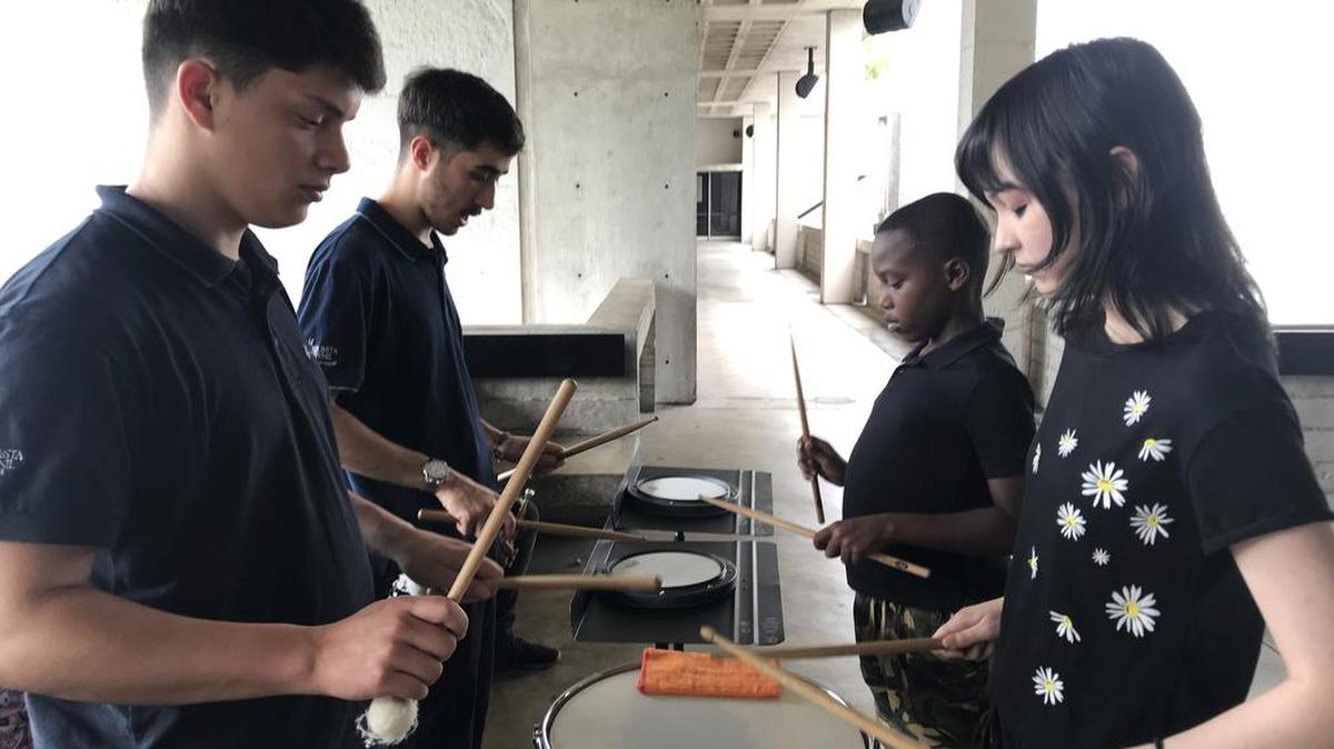 Sixteen-year-old Joyce O’Conner, right, and Jonathan Aina, 10, left, learn from two percussion specialists from the National Youth Orchestra of Uruguay. Facundo Tourinomonte, left, and Federico Gonzalez, right, were part of the group’s recent visit to the South Florida Youth Symphony Summer Music Academy.
