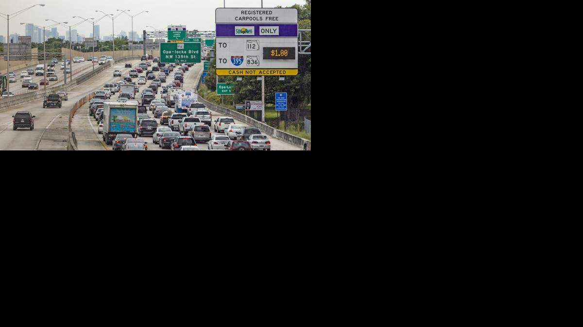 
Southbound traffic headed towards the Miami skyline in the four unrestricted I-95 lanes, at right, near the Golden Glades intersection at State Highway 826 in Miami, Florida, on Thursday, Sept. 11, 2014, is at a standstill due to a traffic accident, while the two southbound express toll lanes were unaffected. At right, northbound I-95 traffic flows at a normal pace in both the unrestricted (far right) I-95 lanes and the I-95 express toll lanes. In both directions, orange barrier poles separate the normal and toll lanes. 

