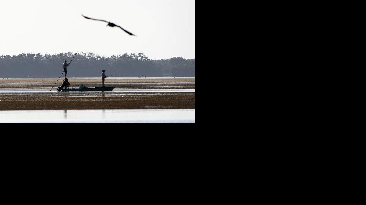 
A fisherman poles his boat in the shallows of Snake Bight in Florida Bay in Everglades National Park.
