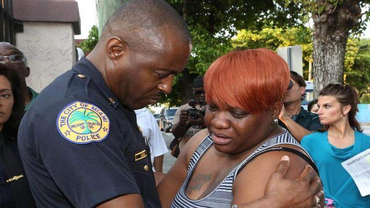 
Miami Police Major Delrish Moss consoles Tramele Harris, mother of 16-year-old Richard Hallman, who was shot and killed in Allapattah. 
