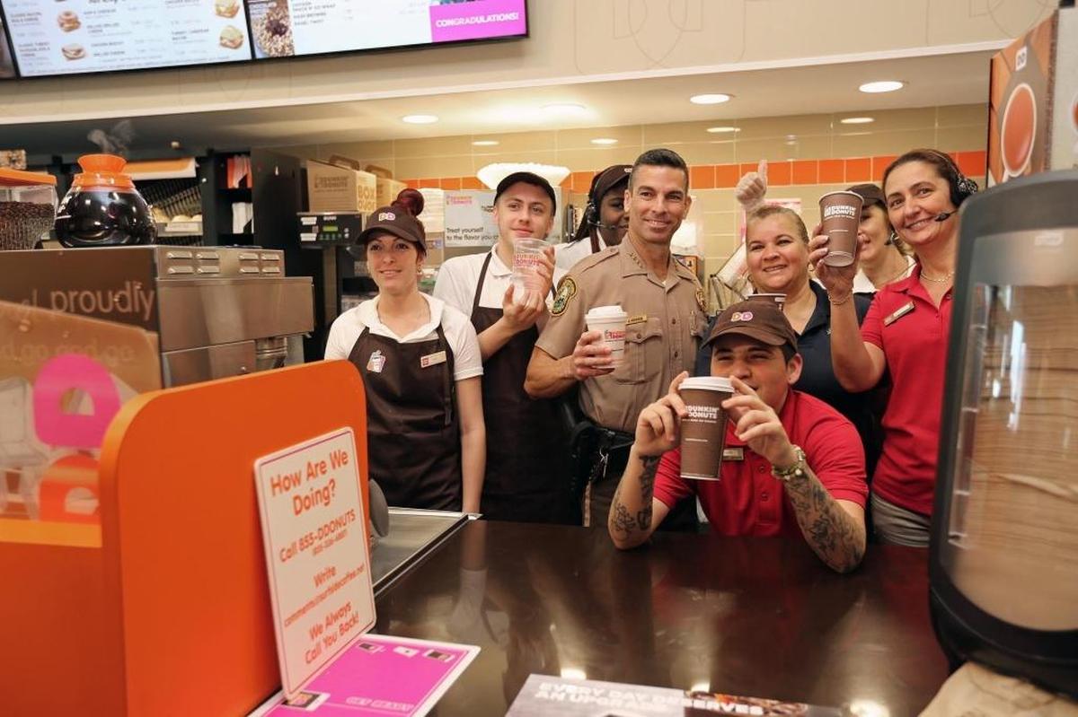 Miami-Dade County Police Director Juan J. Perez takes a picture with the Dunkin' Donuts crew at 7330 NW 36th St. as the Miami-Dade police officers host a public meet-up on Thursday, June 15, 2017.