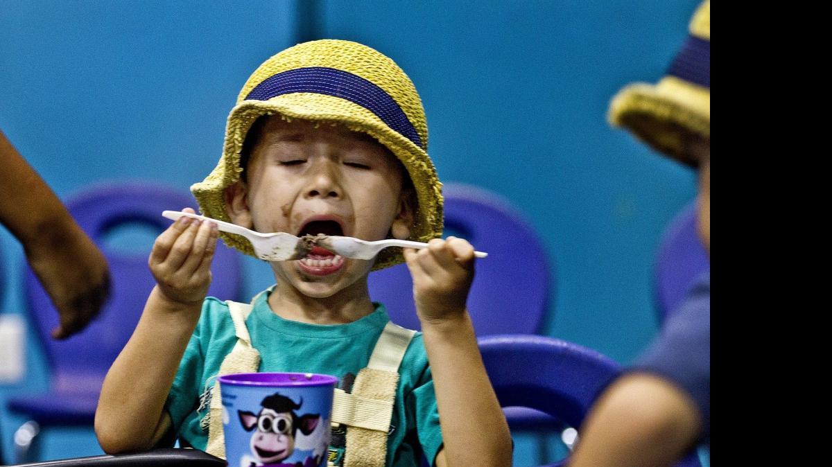 
Matias Bennett 3, of Washington, D.C., enjoys a couple spoonfuls of ice cream on National Ice Cream Day at the Miami Children's Museum on Sunday, July 19, 2015.
