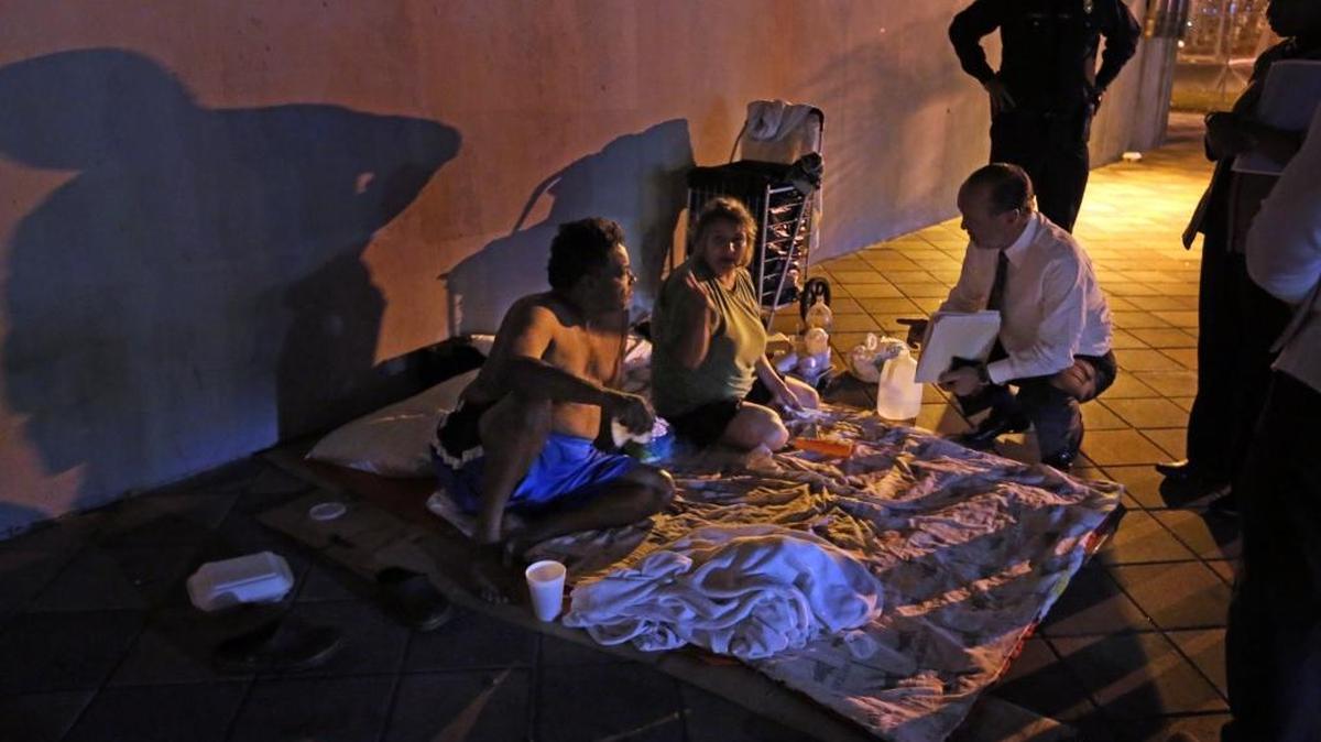 Ron Book, chair of the Miami-Dade County Homeless Trust, talks to a married, homeless couple who were camped out underneath a bridge in January 2015. Book, along with a team of workers and volunteers, were participating in the annual count of the homeless population.