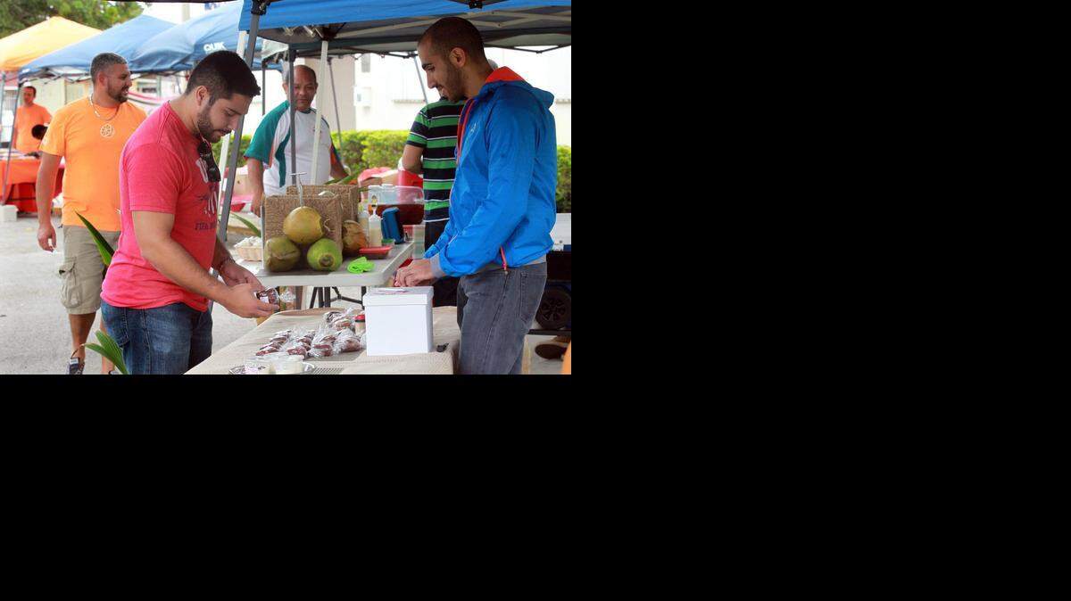 
Javier Navas, left, picks out muffins from Danny Sleiman at the new farmer's market, Saturday, November 22, 2014. The market opened up in Sweetwater at Ronselli park, located on Southwest 114th Avenue at Southwest Second Street.
