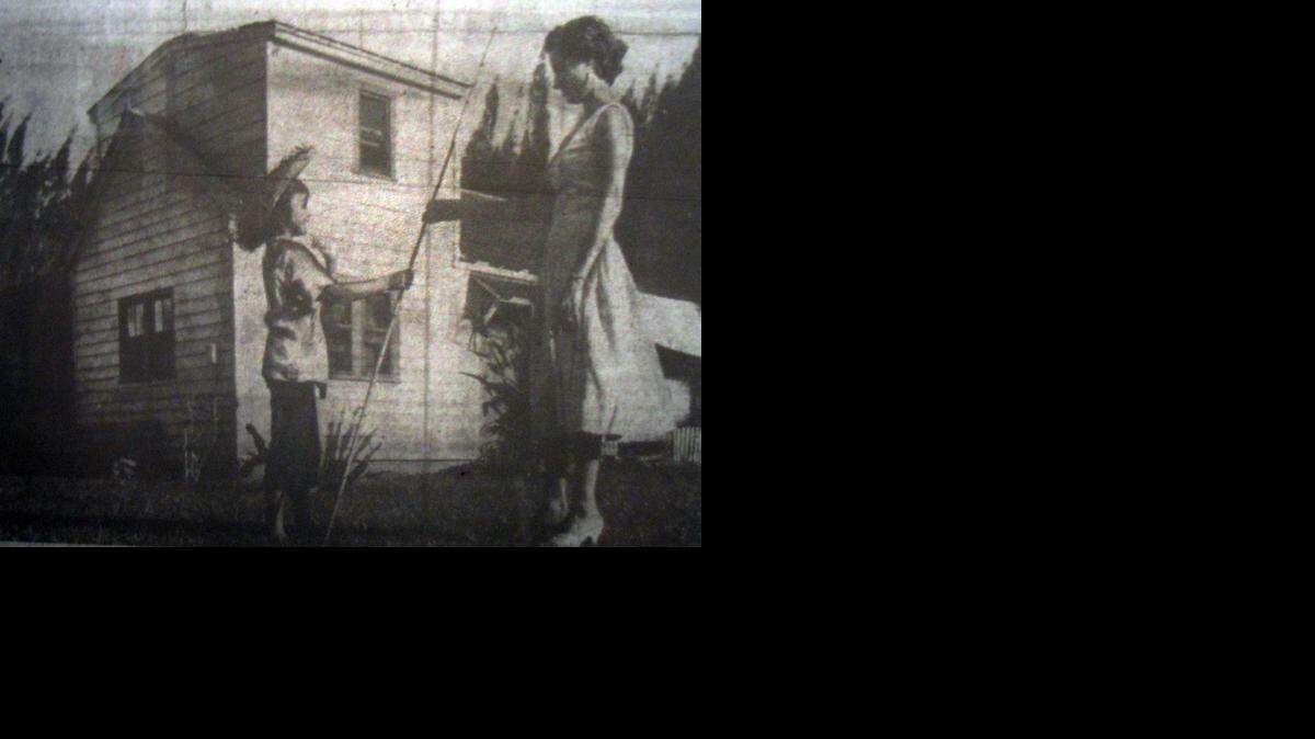 
Donna Marie Notay, 9, and Mrs. Charles Pastore, the former mayor's wife, pose in front of the "three-in-one midget house" that was torn down decades ago in Sweetwater. 
