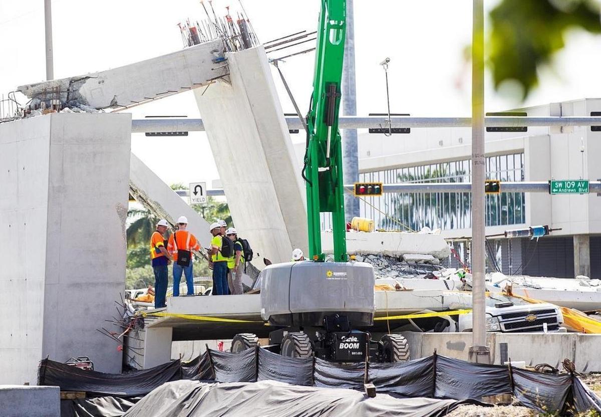 Inspectors huddle around the northern end of the Florida International University bridge, where workers were adjusting tensioning cables and cracks appeared before the bridge collapsed on March 15.