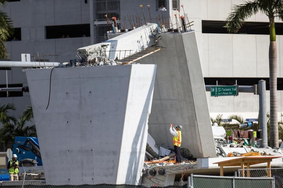 A National Transportation Safety Board investigator photographs the north end where cracks were reported and workers were adjusting tensioning cables before the bridge suddenly collapsed March 10.