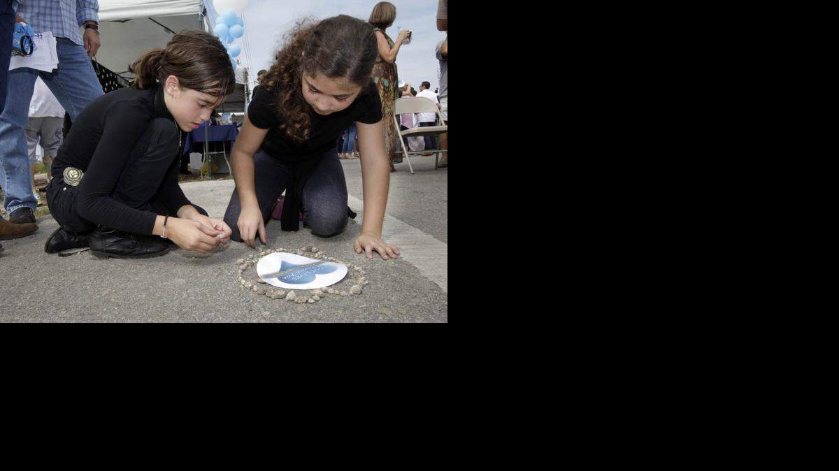 
Kailey Lopez, left, and Sophia Rodriguez make a memorial. A ceremony was held Saturday to remember those killed in collisions on Krome Avenue and lobby local and state officials to revamp the 37-mile stretch known to many as “Killer Krome.” 

