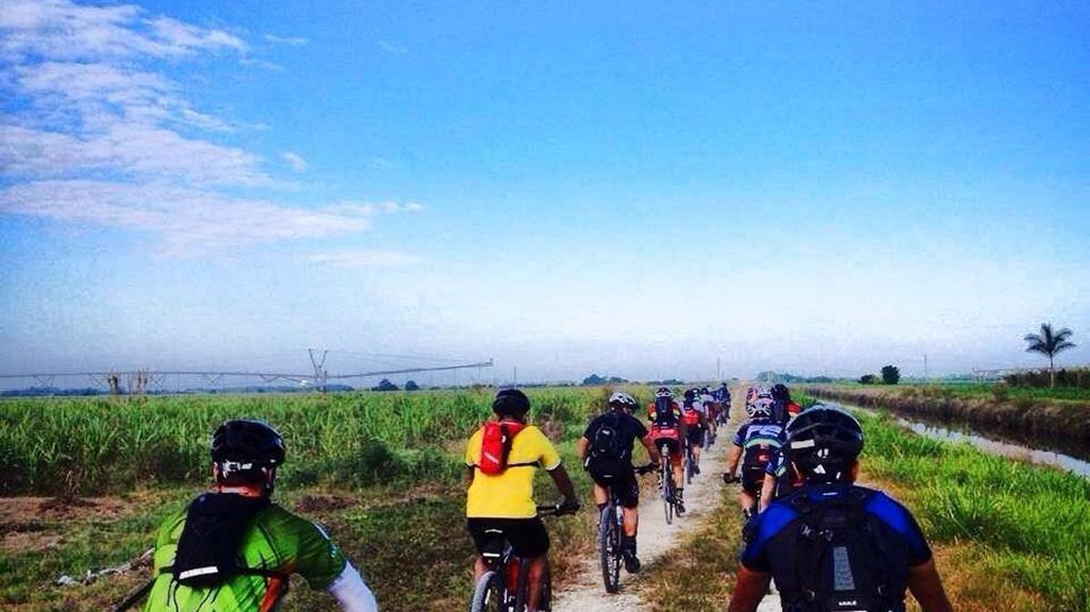 Cyclists ride on a gravel trail along a canal and a farm field in South Miami-Dade during a previous Great Gator Gravel Grinder.