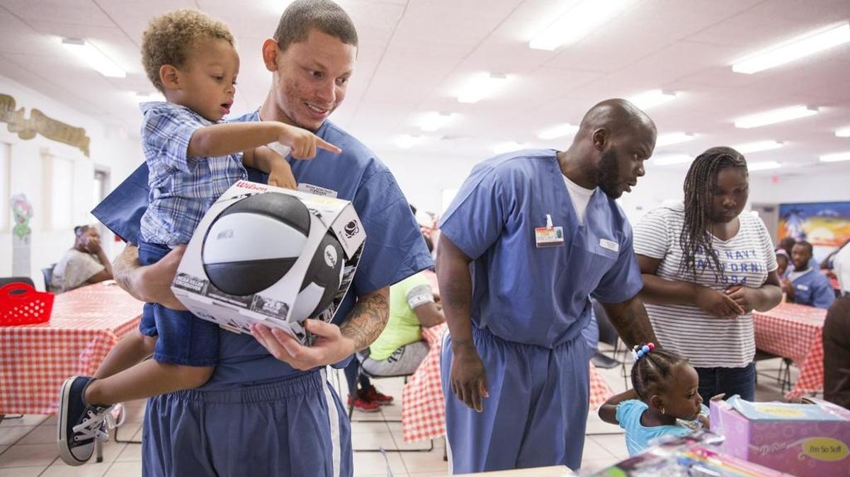 Demetrius Moore, 24, helps Demetrius Moore Jr., 2, pick out a toy to play with at Everglades Re-Entry Center on the campus of Everglades Correctional Institution in 2015.