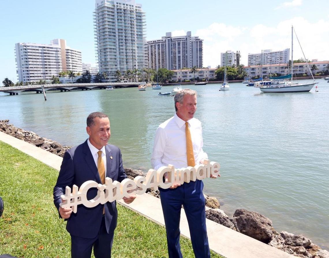 Miami Beach Mayor Philip Levine and New York Mayor Bill de Blasio hold a sign for Cities4Climate following their tour of Sunset Harbor to view Miami Beach’s efforts against sea-level rise.