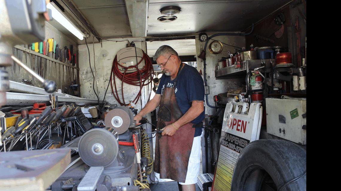 
Sharpener Jorge Luis Gonsález works on a knife inside his “Mastodon” truck. Gonsález has been earning a living sharpening knives and tools since he immigrated from Cuba 35 years ago. 

