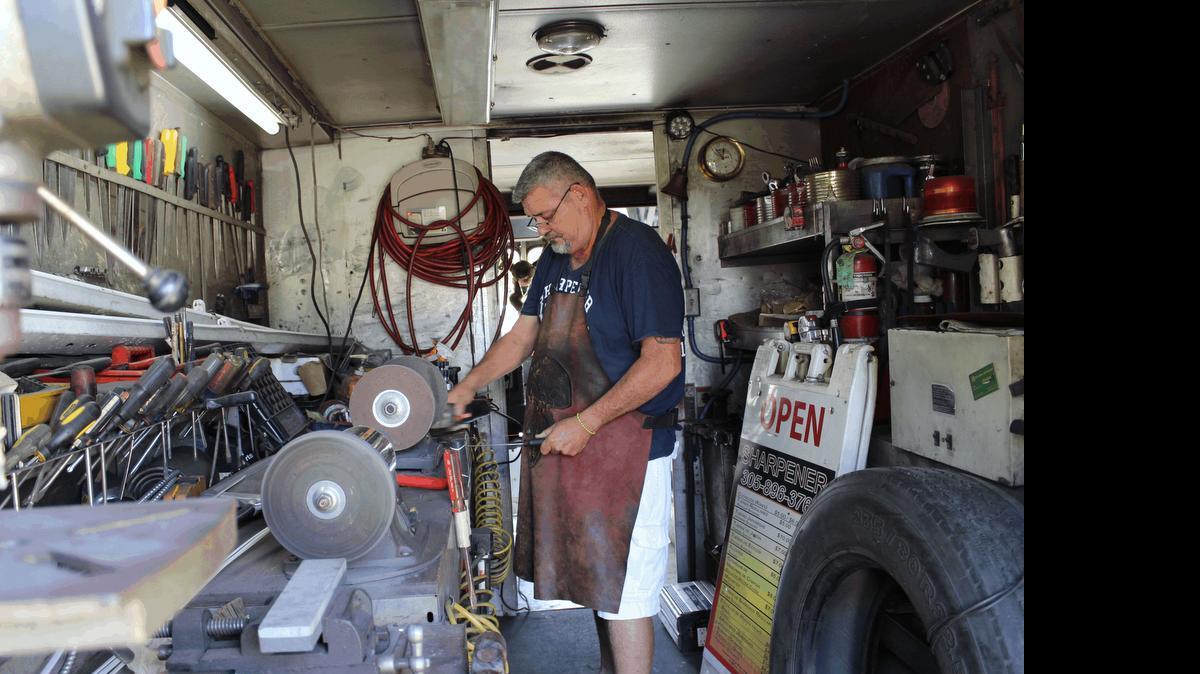 
Sharpener Jorge Luis Gonsález works on a knife inside his “Mastodon” truck. Gonsález has been earning a living sharpening knives and tools since he immigrated from Cuba 35 years ago. 

