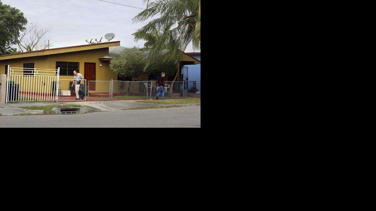 
A resident, left, of the New Greenview II assisted living facility home in Miami carries out the trash on Friday, March 13, 2015. The ALF, at 2650 NW 15th Ave. in Allapattah-west Wynwood, concerns neighbors, who have long complained about its mentally ill residents. Miami-Dade prosecutors recently filed a murder charge against a paranoid schizophrenic man accused of fatally stabbing another man in the throat while on the property. 
