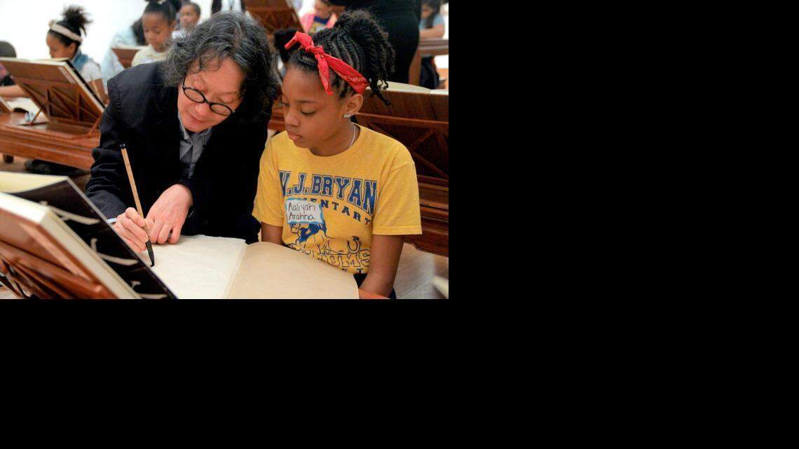 
Chinese art star Xu Bing, left, shows W.J. Bryan Museum Magnet School fifth grader Aaliya Arahna, right, how to do Chinese calligraphy. Fifth grade students visited the Patricia and Phillip Frost Museum at Florida International University to meet Chinese art star Xu Bing and participate in an interactive calligraphy workshop.
