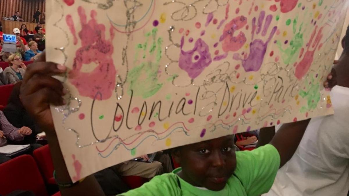 Brandon Wilson, 12, holds a sign supporting Miami-Dade’s Colonial Drive Park during a budget meeting before county commissioners on Tuesday.