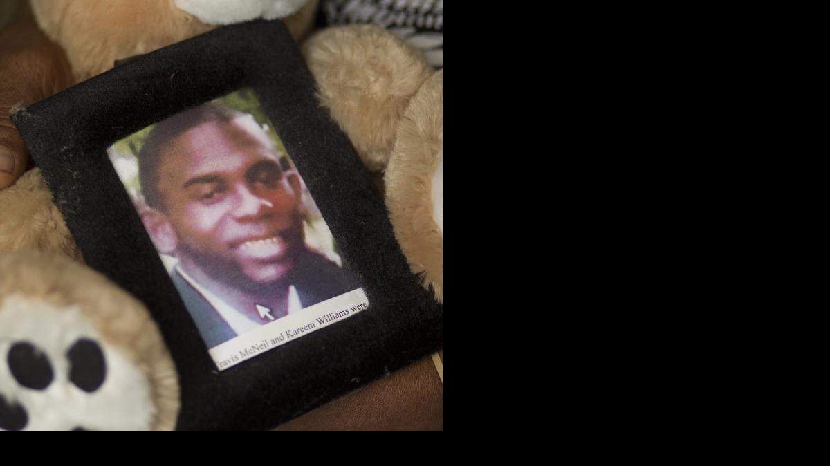 
Sheila McNeil, mother of Travis McNeil, an unarmed Miami man who was fatally shot by a police officer in 2011, holds on to a small portrait of her son while sitting in her livingroom in Overtown in 2013.
