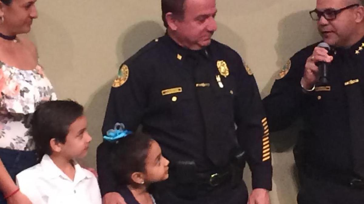 Miami police Cmdr. Freddy D'Agostino, surrounded by his two young children and wife, Doana, retired this week after a lengthy and distinguished career.
