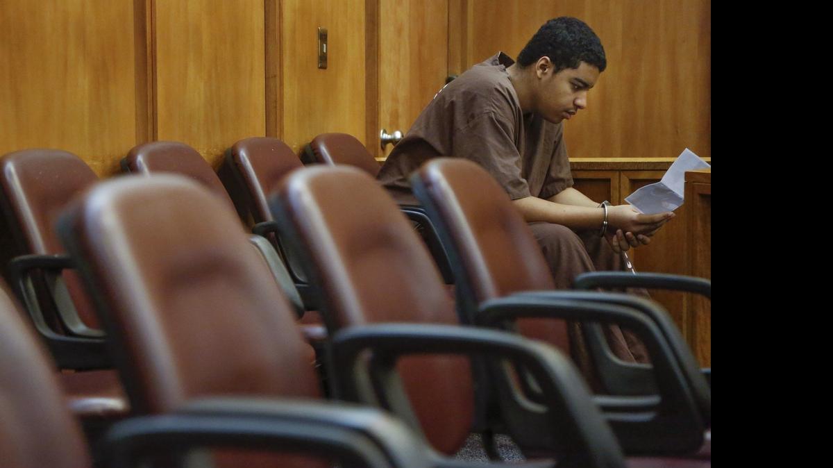 
Marc Wabafiyebazu looks at a photo of his brother after being denied bail on Wednesday, June 3, 2015. The son of Canada’s consul general in Miami, 15-year-old Marc is charged in connection with the marijuana rip-off that ended a gunfight and the death of his older brother, Jean.
