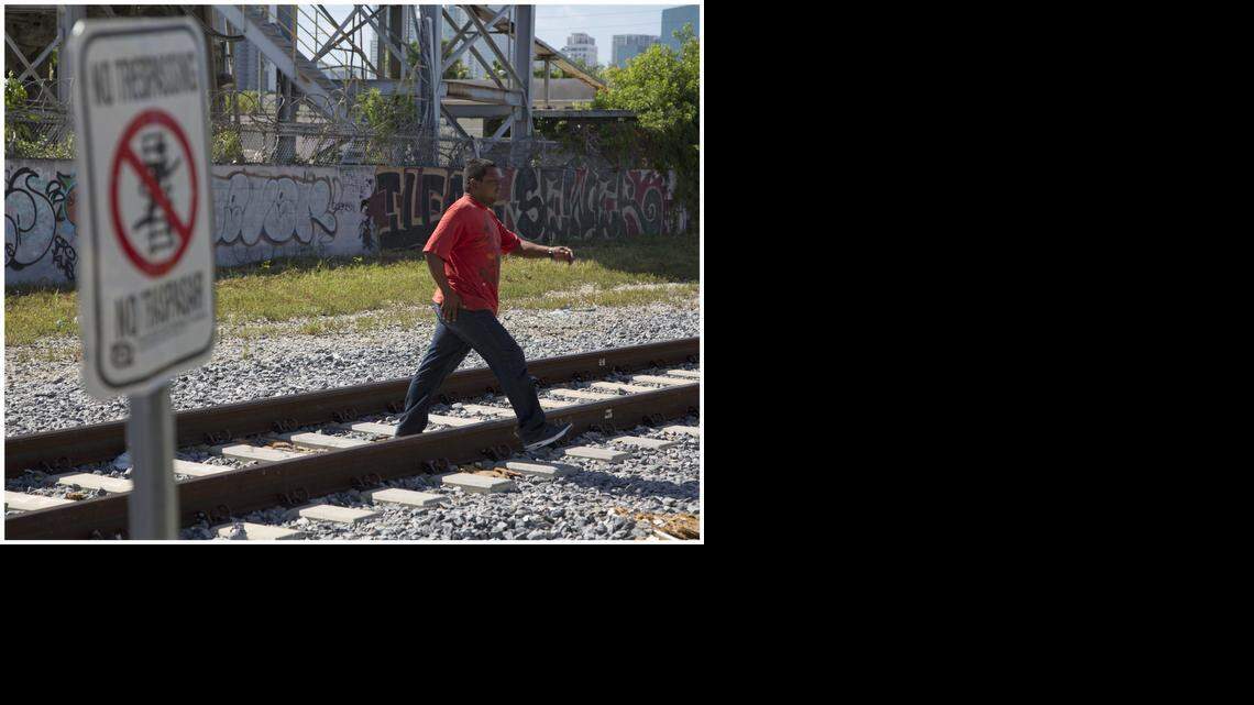 
Locals cross over the train tracks in the 100 block of Northwest 17th Street. Residents complain that Florida East Coast railway police are harassing and arresting them as they try to walk across the streets.
