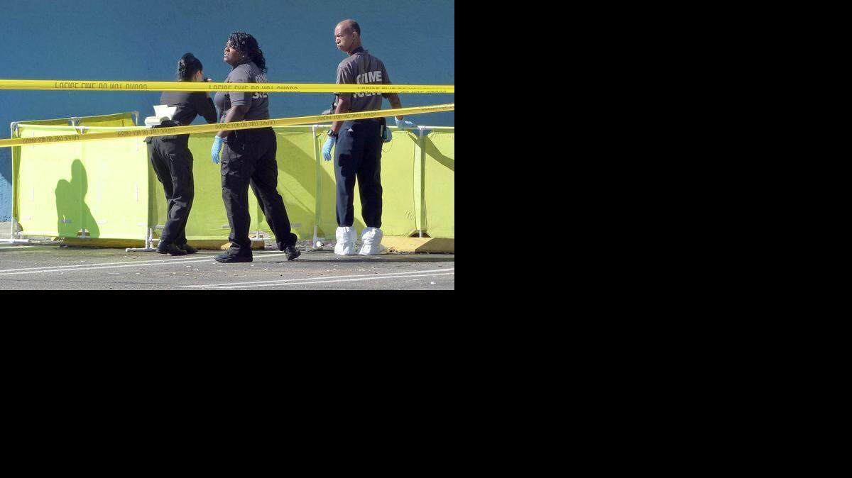 
City of Miami Crime scene investigators photograph the deceased body of a homeless man who died due to trauma in the early morning hours of Friday October 31, 2014 at a Laundromart located on Northwest Seventh Street and 12th Court in Miami. Police said that the man's head was very bloody and that trauma to the head is a possibility.

