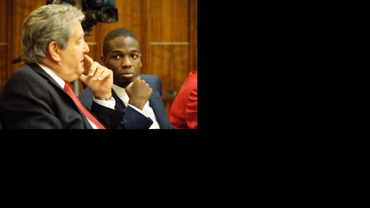 
Accused Miami cop killer Andrew Rolle in court Friday, with lawyer David Peckins, as his trial for murder begins.
