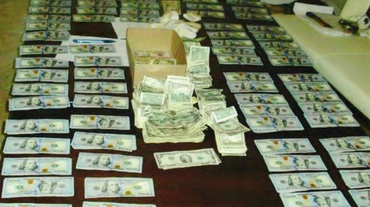 Some of the assets seized by federal agents when they arrested Jorge Lorenzo and his wife last week at their home in the 900 block of Southwest 94th Avenue, are shown in this photo released by the U.S. Attorney's Office. They found a safe containing $102,000 in cash, a painting by a prominent Cuban artist valued at $25,000, and dozens of Rolex and Cartier watches.