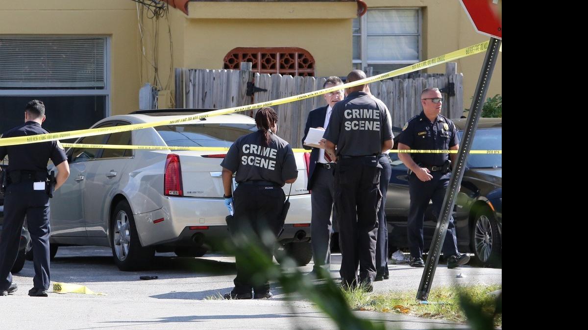 
Crime scene investigators scour for evidence at Southwest 36th Avenue and 17th Street, where at least three people were shot on March 30, 2015. 
