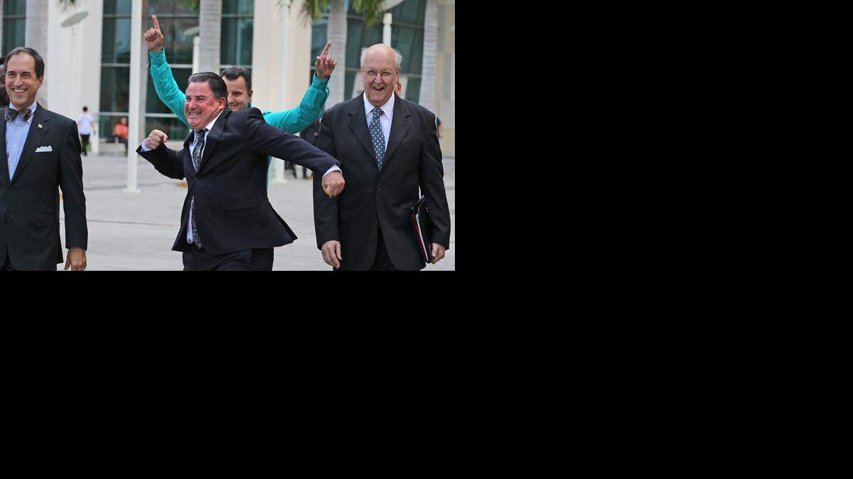 
Miami Lakes Mayor Michael Pizzi, flanked by his attorneys Benedict Kuehne and Ed Shohat, reacts outside the Miami federal courthouse in August after being found not guilty of accepting payoffs.
