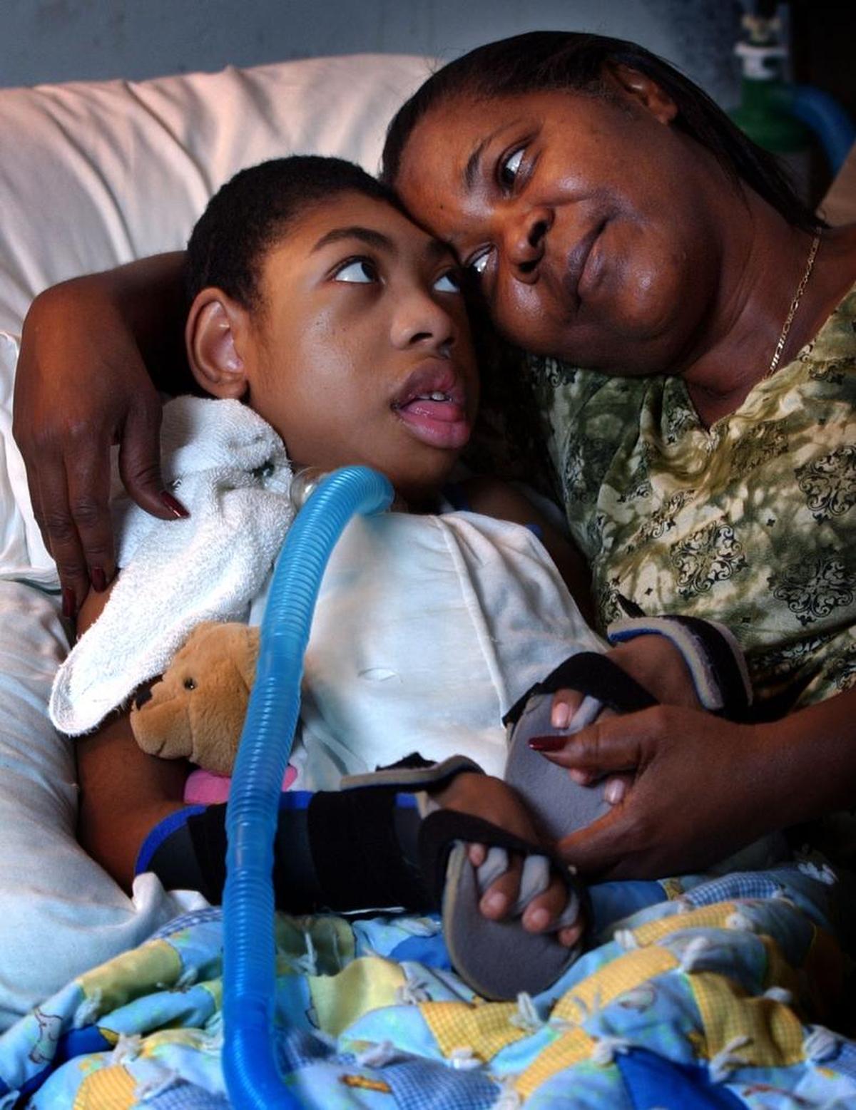 Margaret Coakley-Dyke cuddled with her grandson, Julius Dyke, then 10, in her Fort Lauderdale home in this 2003 photo. Her 18-year-old daughter, Lisa, was stabbed to death while Julius was in utero in 1993.