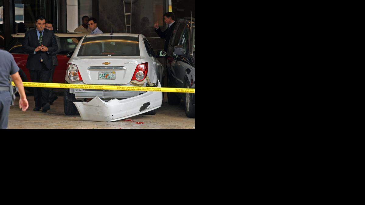 
Hotel and valet employees survey the damaged cars at the scene where several people were struck by a carjacker as he raced out of the JW Marriott Marquis in a late model luxury car on Wednesday, September 24, 2014 in downtown Miami.
