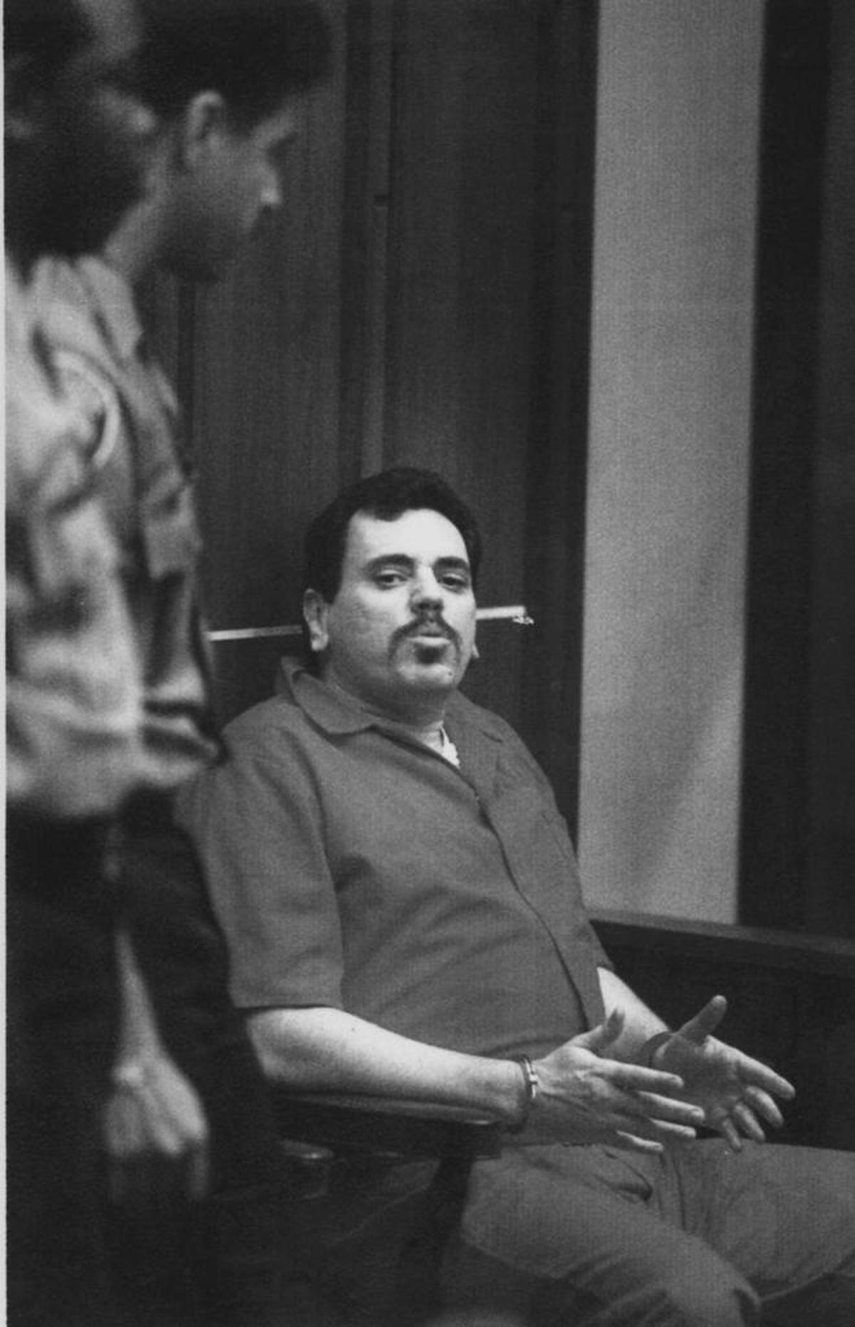 ARONOW MURDER SUSPECT: Benjamin Kramer, in handcuffs, was accused of killing speedboat builder Don Aronow. He was in the Metro Justice Building in Miami in this April 1, 1993 photo. Kramer was sentenced to 19 years in jail and would die in Miami at age 60 in 2009.