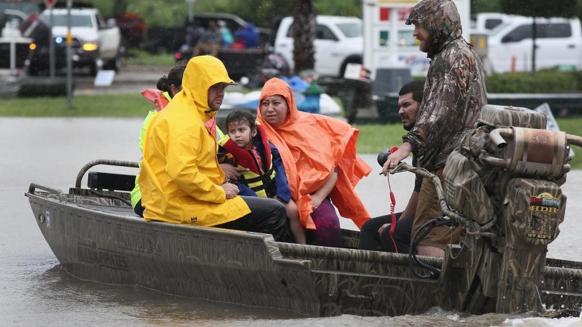 Rescue workers and volunteers help residents make their way out of a flooded neighborhood after it was inundated with rain water following Hurricane Harvey on Aug. 29, 2017 in Houston, Texas.
