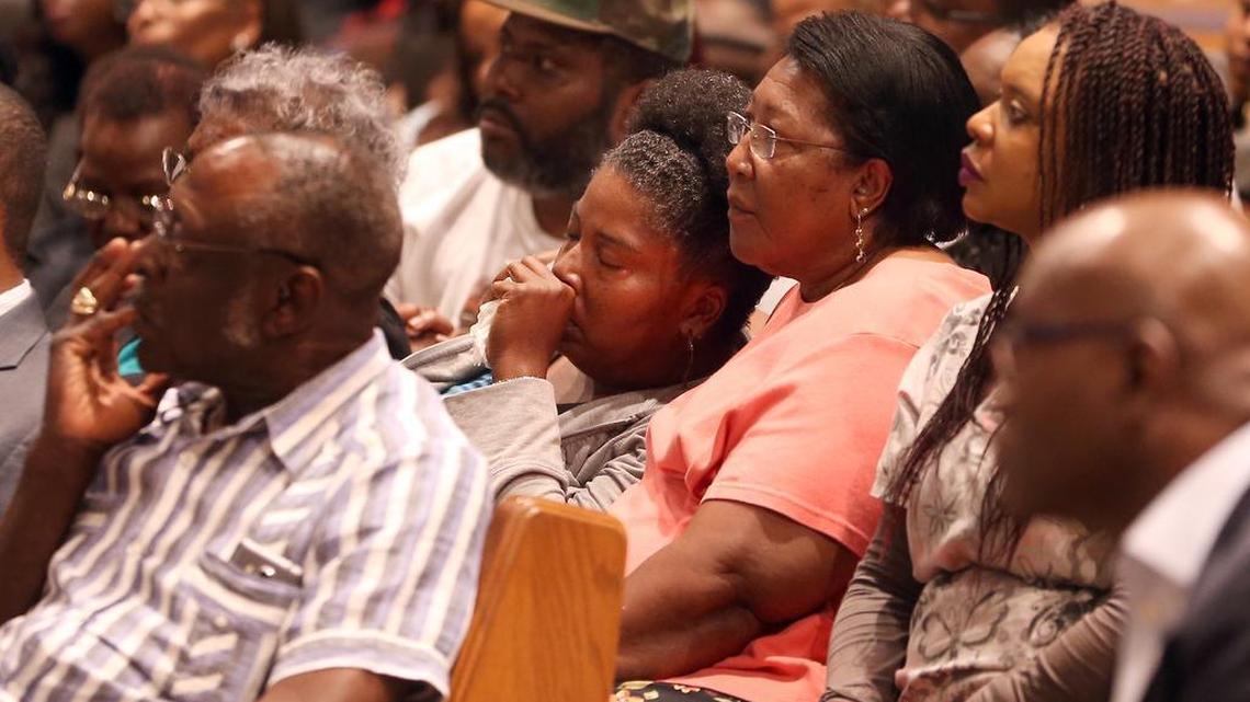 Sybil Harris (center), the mother of Jamar Rollins, is consoled at a community meeting at Sweet Home Missionary Baptist Church on Tuesday.