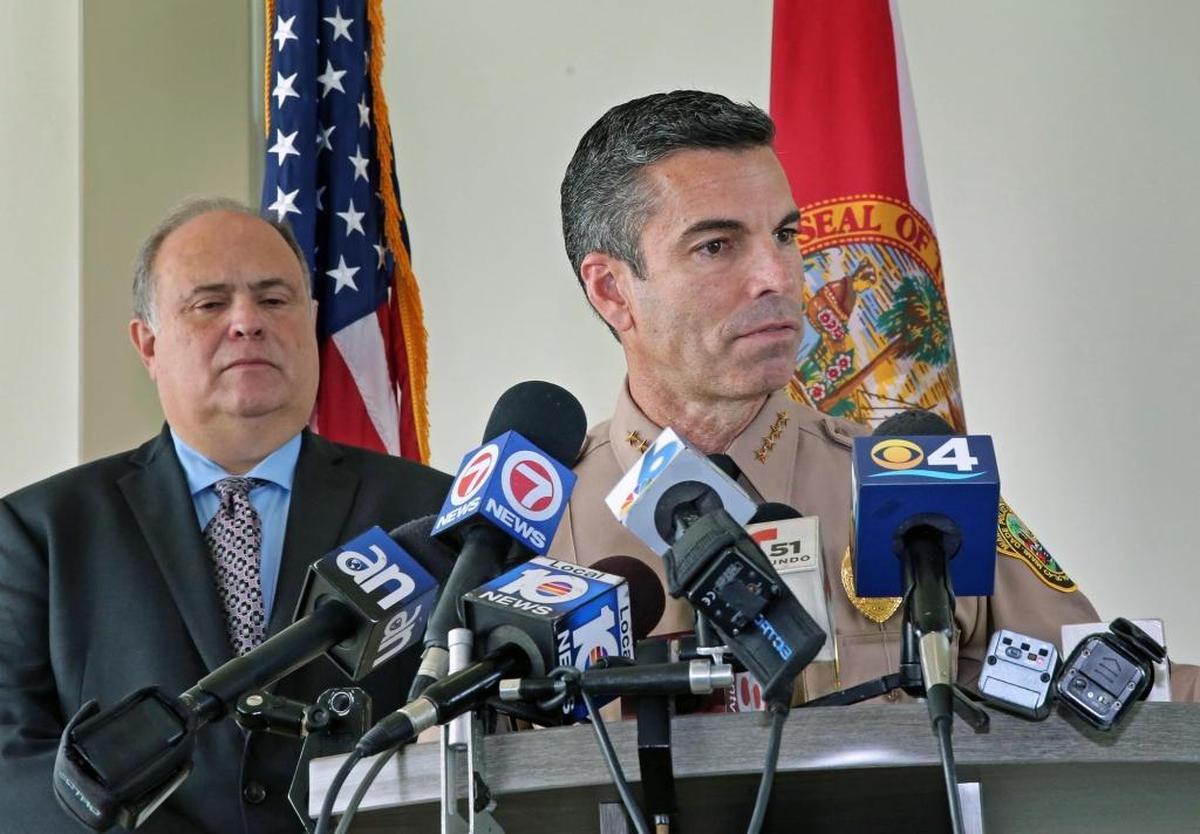 Juan Perez, director of the Miami-Dade Police Department, speaks at a press conference in Doral to discuss the status of off-duty Doral Police Lt. Gary King, who was confronted in his driveway by at least two men who stole his gun and shot him late Jan. 16, 2018. Behind him is Doral Mayor Juan Carlos Bermudez.