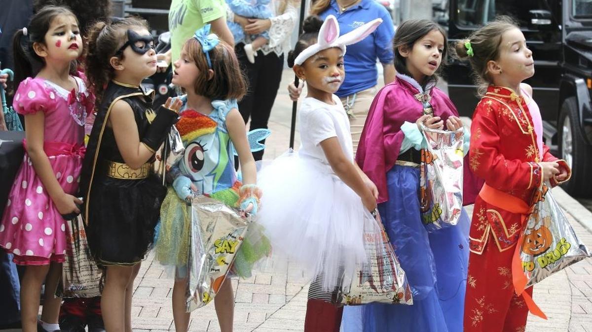 Brightly-costumed girls from Southside Elementary School wait in line to collect more candy during a pre-Halloween parade on Friday, Oct. 28, 2016 at the Shops at Mary Brickell Village.