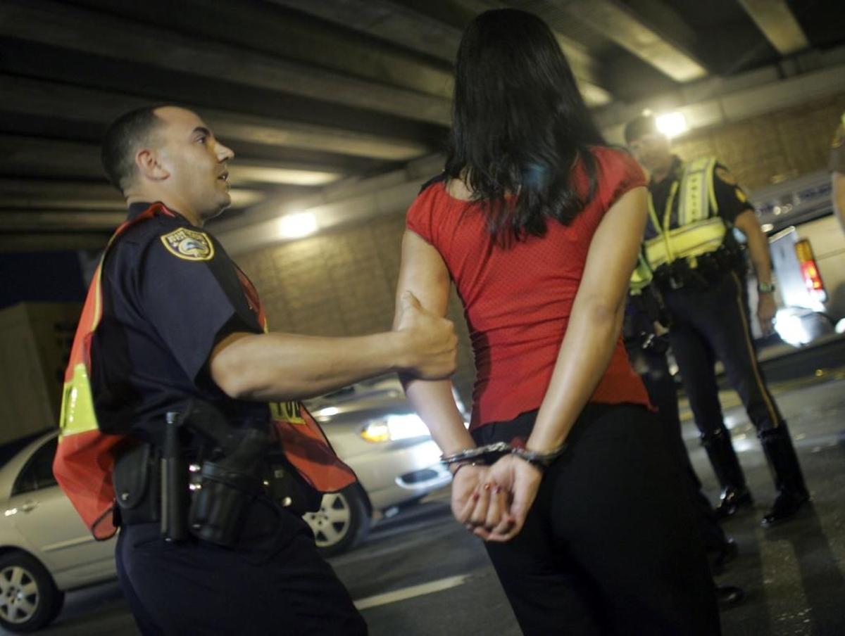 A Miami Beach police officer arrests a woman after she failed a field sobriety test at a DUI checkpoint