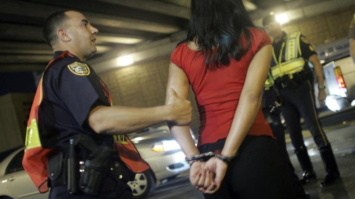 Officer Kevin Millan from the City of Miami Beach police department arrests a woman after she failed a field sobriety test at a DUI checkpoint in 2006 in Miami.