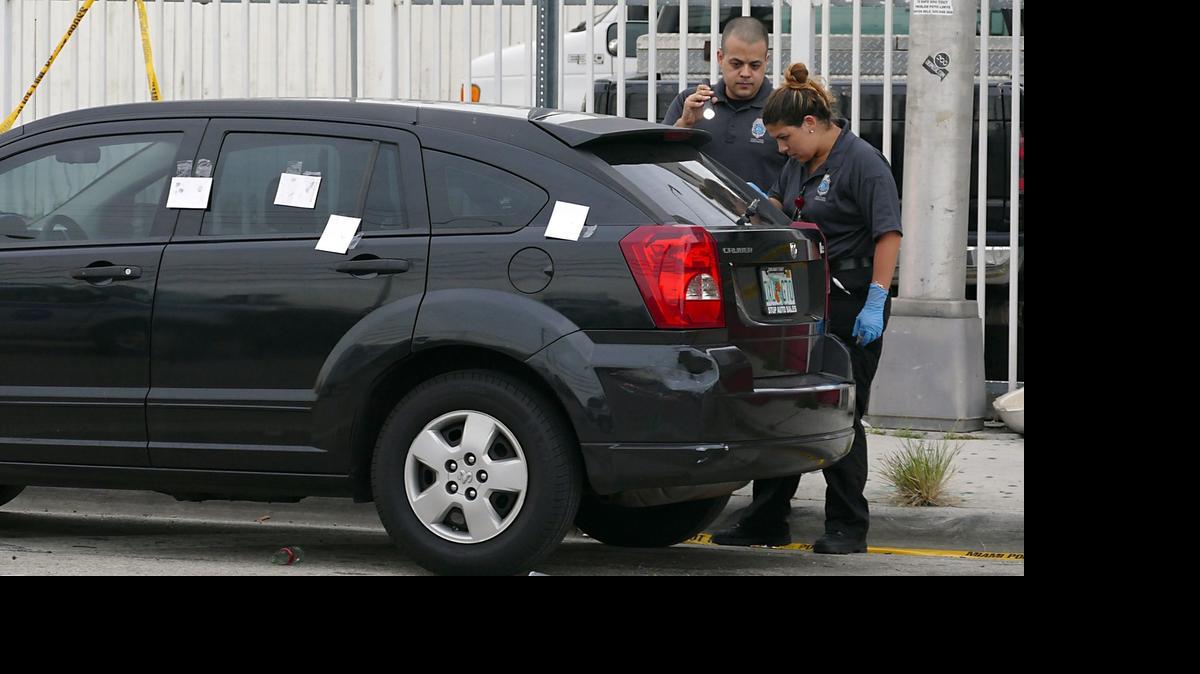 
Crime scene investigators look over a Dodge Caliber nearby The Flow Bar & Lounge, 2400 block of NW 36th Street, where multiple people were shot outside the establishment Friday June 12, 2015.
