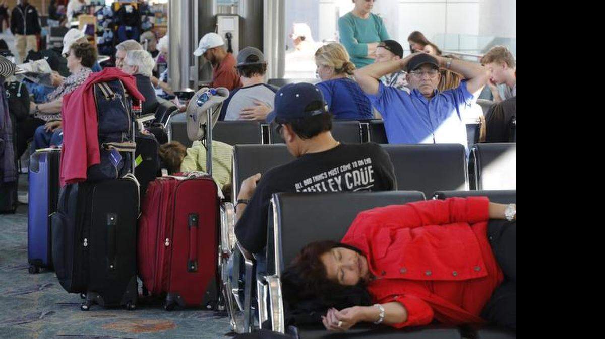 
Holiday travelers sit, sleep, and relax while waiting to depart from Fort Lauderdale-Hollywood International Airport, Terminal 1 on Monday.
